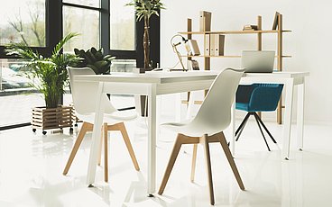 Tisch mit Stühlen in minimalistisch eingerichtetem Raum